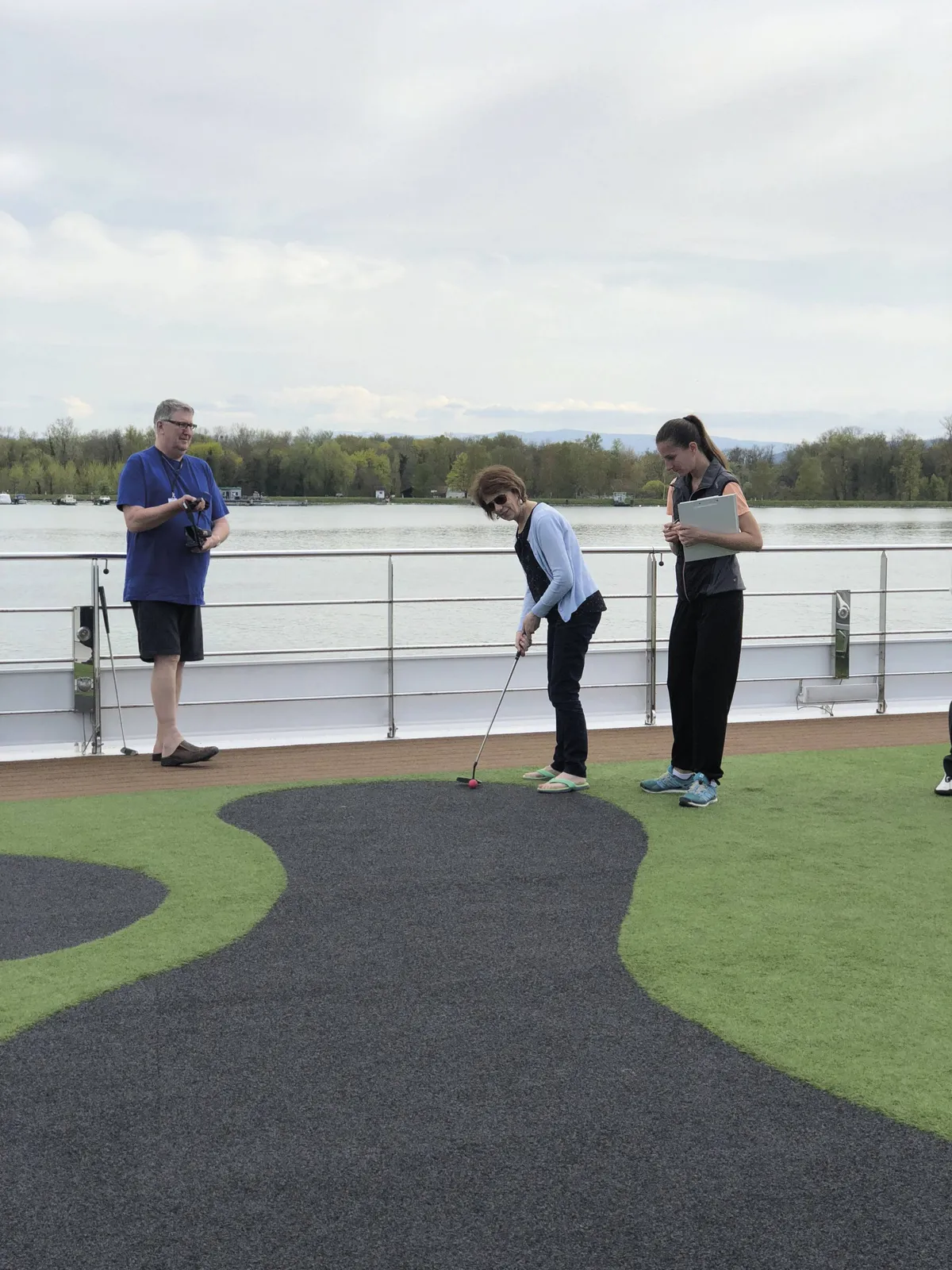 Guest practicing golf putting on the ship's sun deck