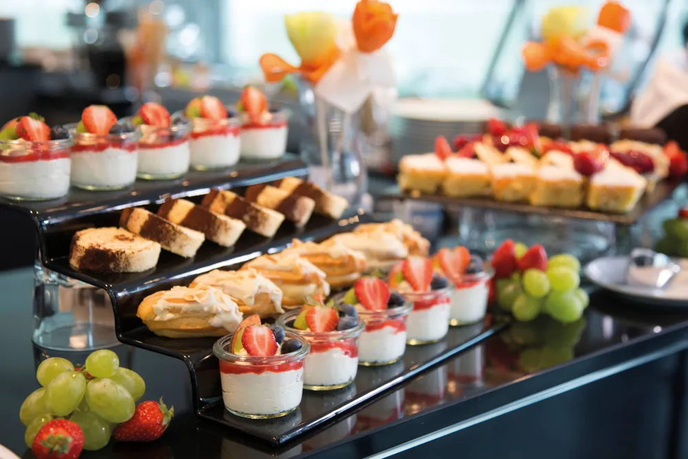 Gourmet food display featuring fresh pastries, desserts, and fruits